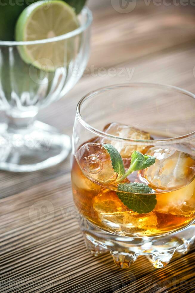 bicchiere di rum sullo sfondo di legno foto