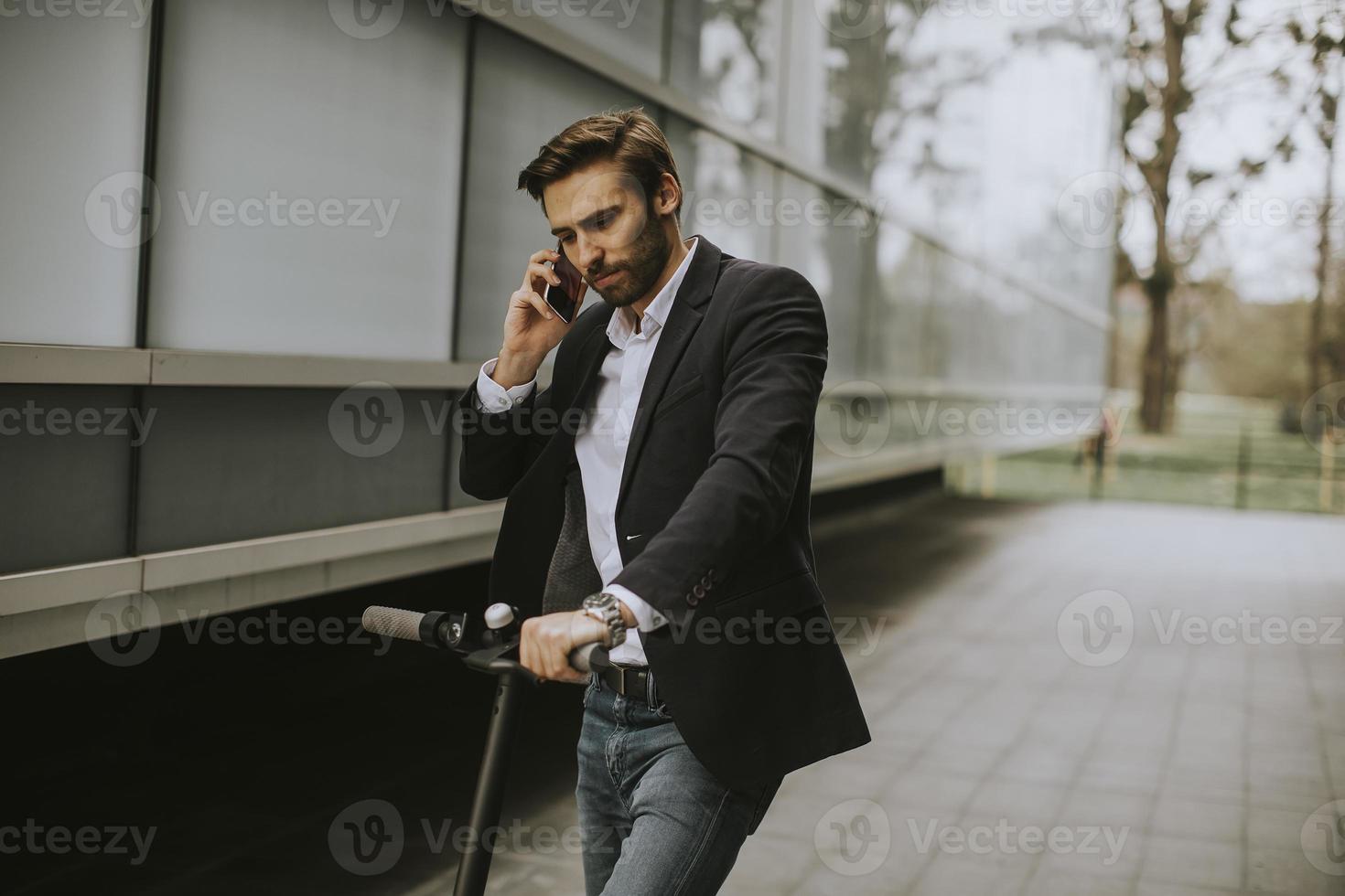 uomo che parla al telefono su uno scooter foto