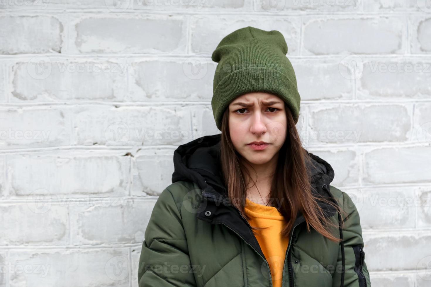 ritratto di una bella ragazza triste con un maglione giallo e un cappello cachi foto