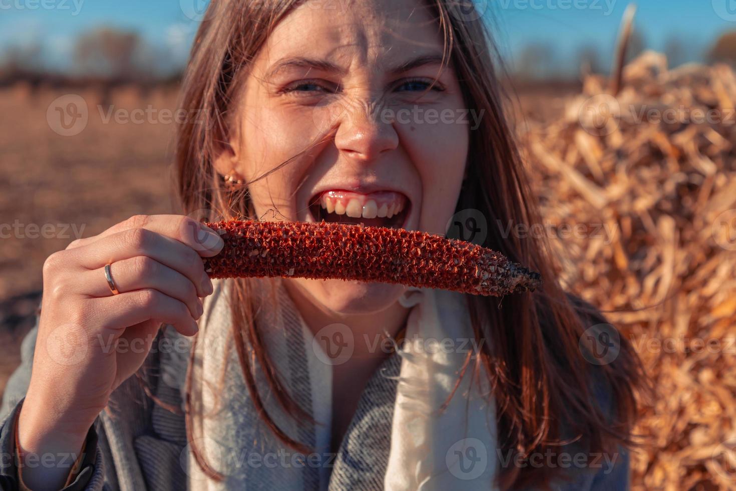 ragazza tiene un'altalena di mais vicino alla sua bocca foto