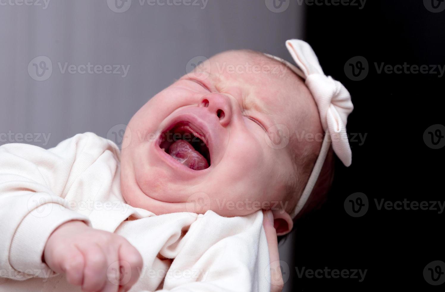 bambina di un mese urla e piange in sua madre foto