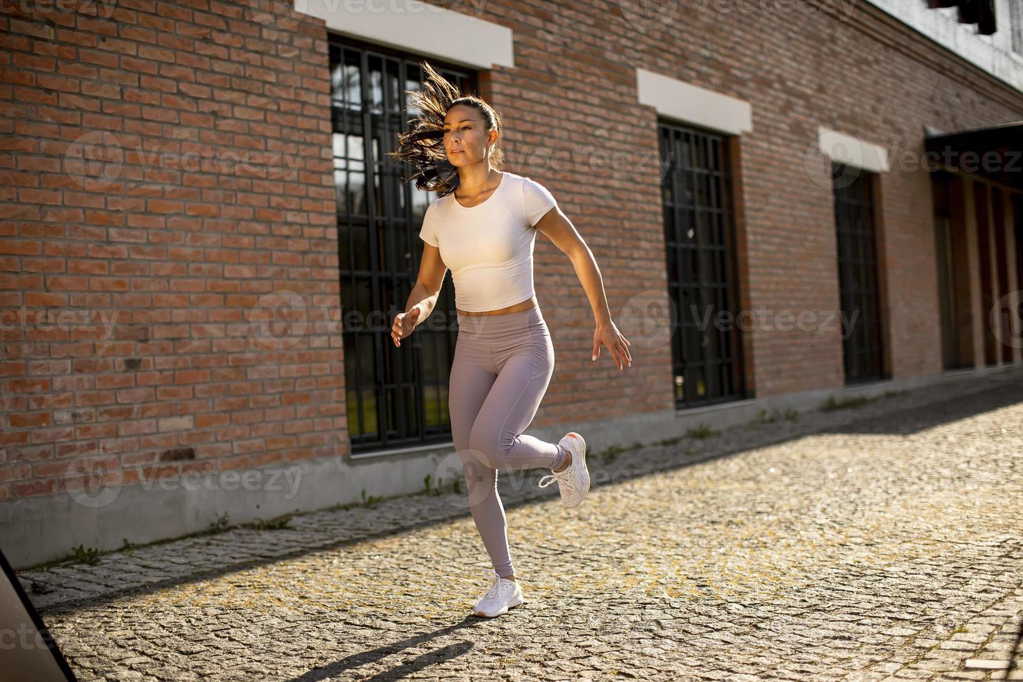 giovane donna che corre sulla strada foto