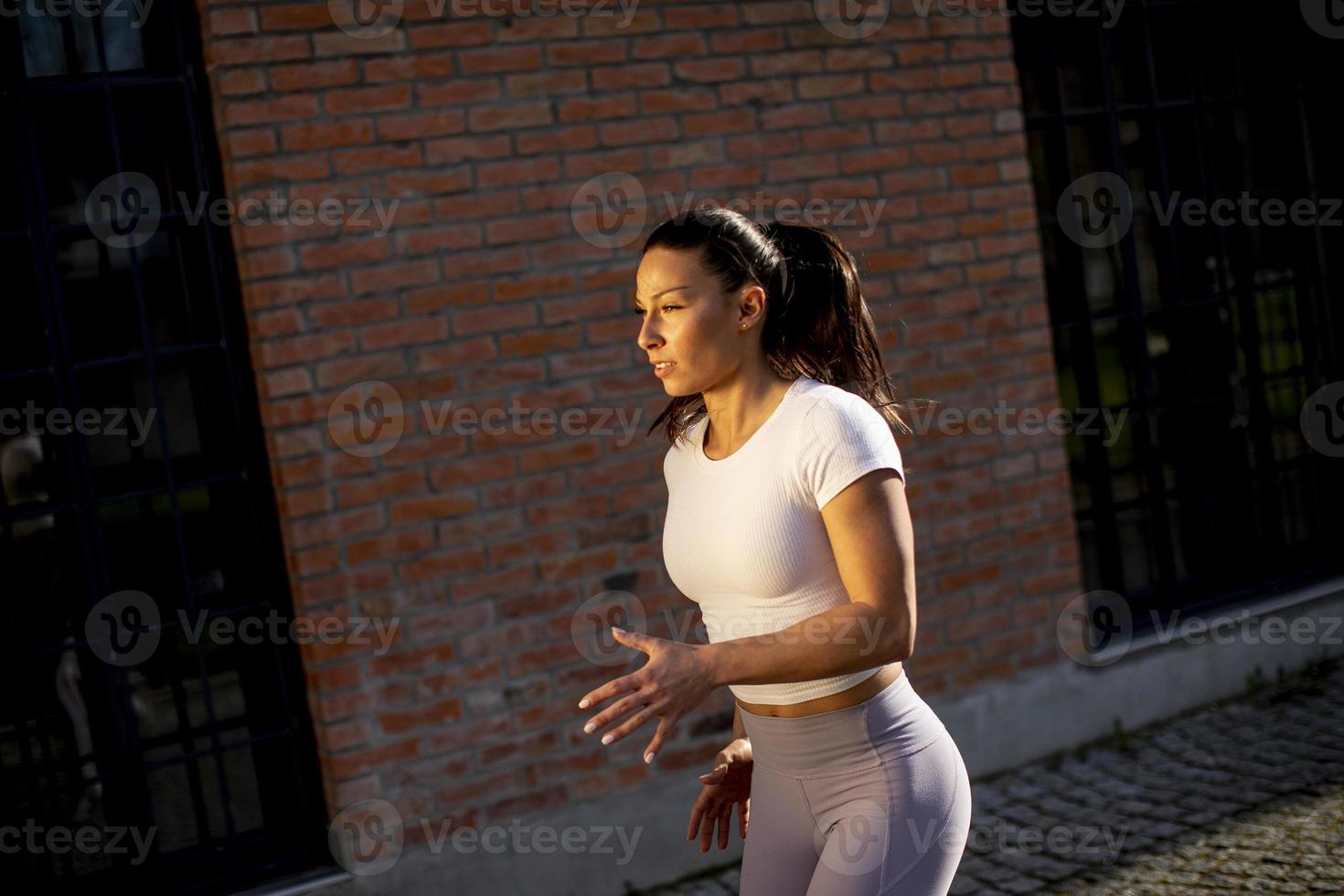 giovane donna che corre sulla strada foto