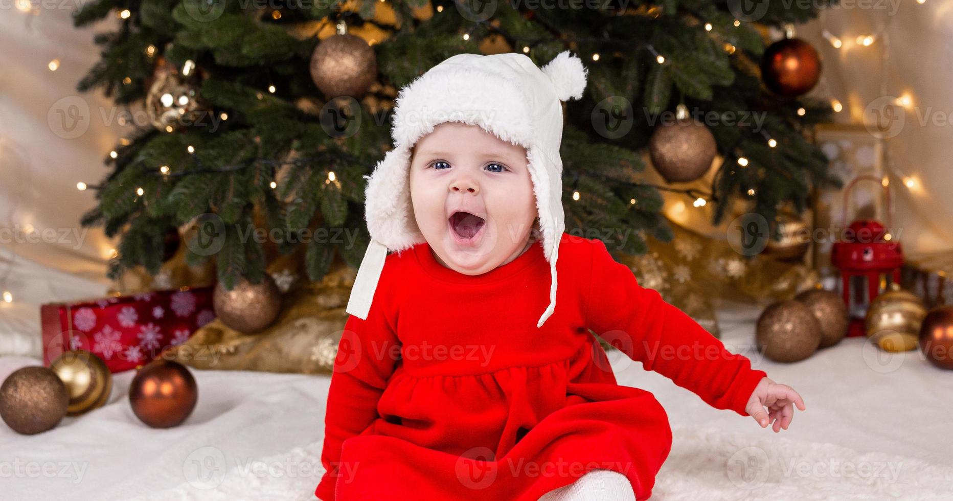 una bambina carina in un vestito rosso e un cappello bianco esprime emozioni foto