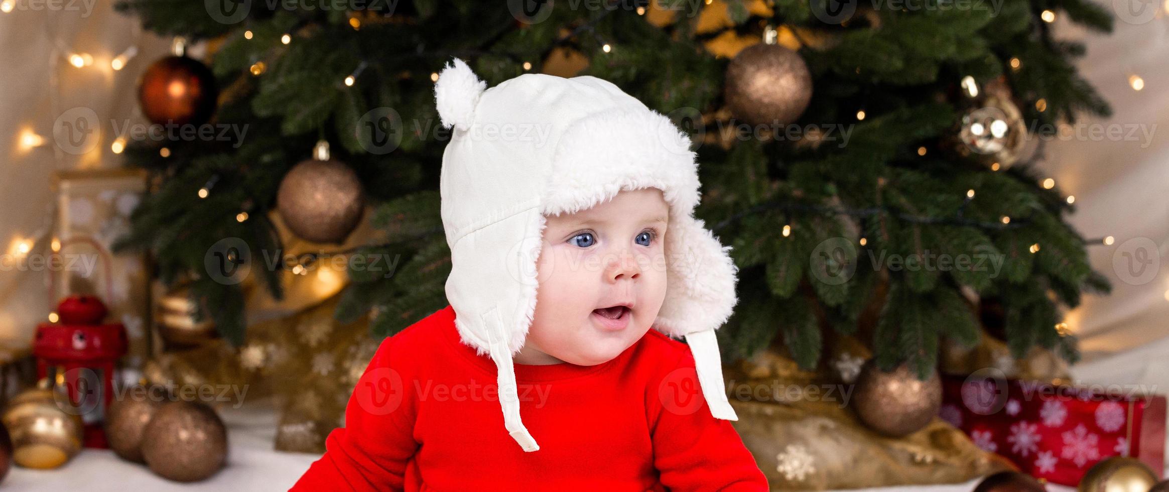 una bambina carina in un vestito rosso e un cappello bianco esprime emozioni foto