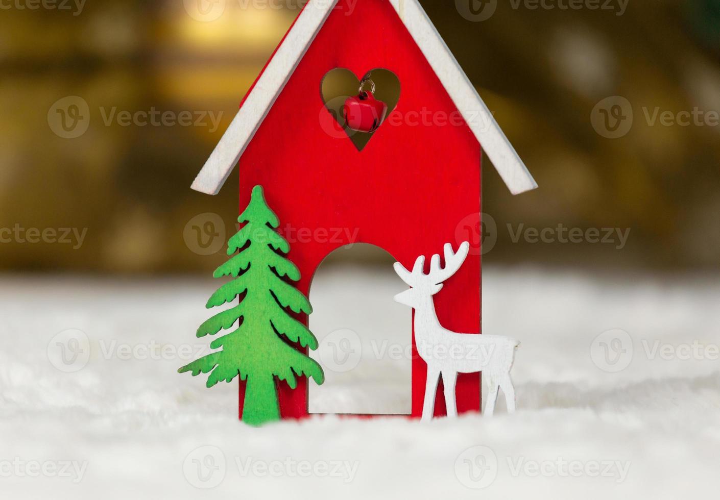 cervo di casa di legno del giocattolo di Natale e albero su una coperta bianca che imita la neve foto