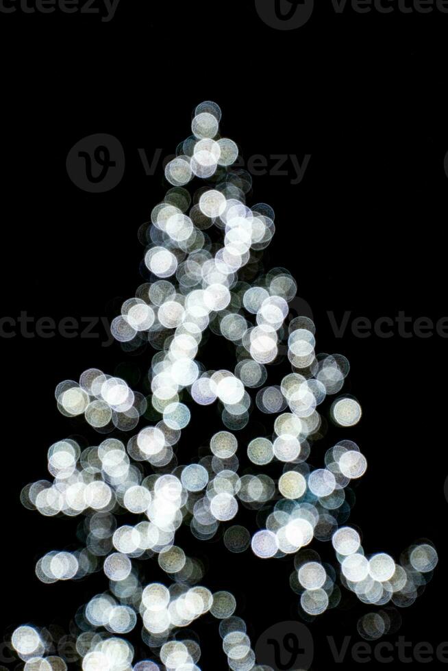 sfocato luci illuminante il Natale albero su un' nero sfondo foto