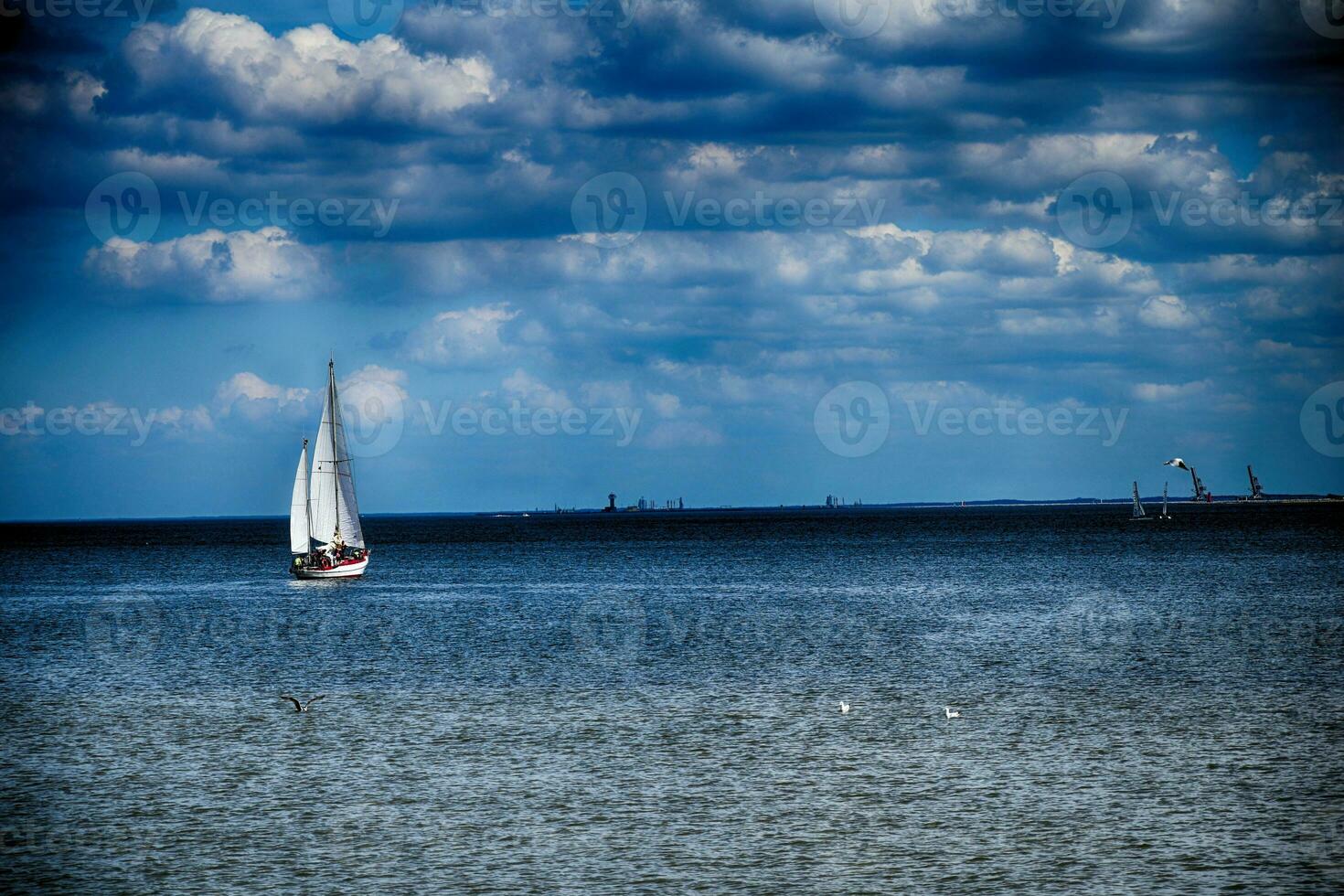 blu paesaggio con il mare e un' bianca barca a vela su il orizzonte su il disco baia nel Polonia foto