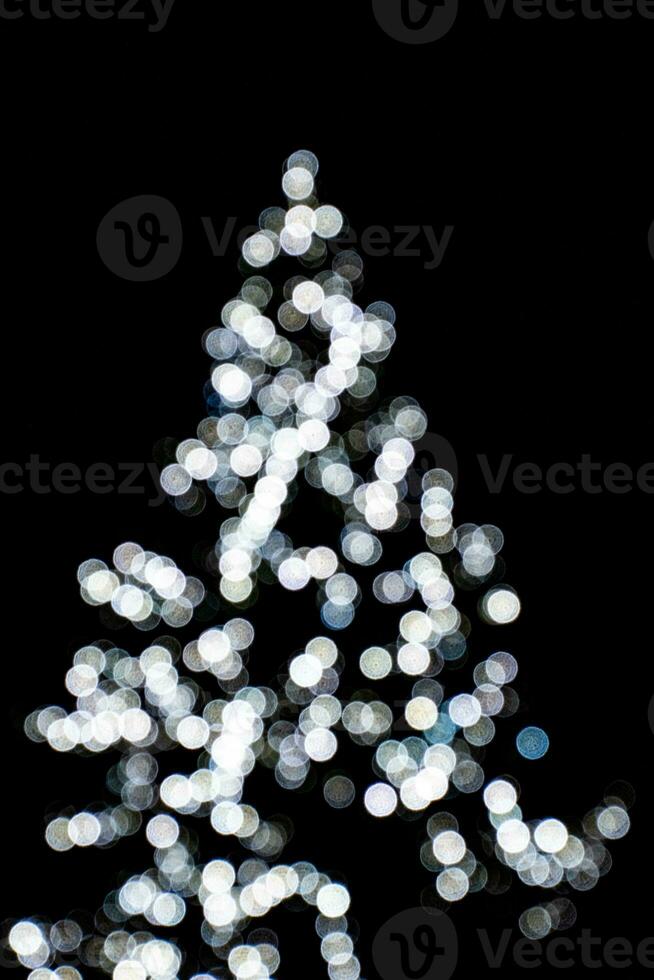 sfocato luci illuminante il Natale albero su un' nero sfondo foto