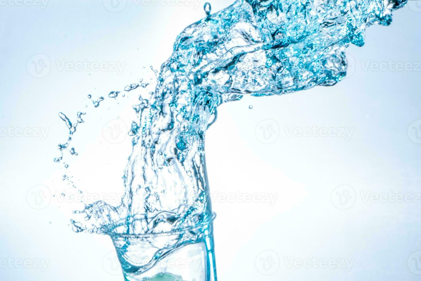 potabile acqua spruzzi a partire dal il bicchiere su bianca sfondo foto