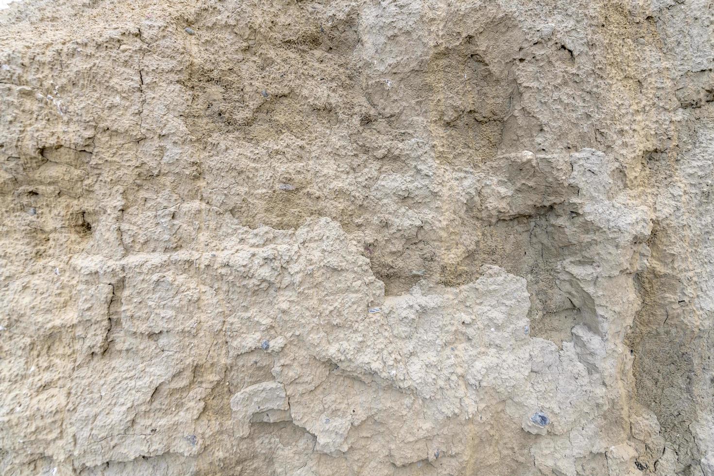 muro di sabbia di sabbia chiara con piccoli ciottoli foto