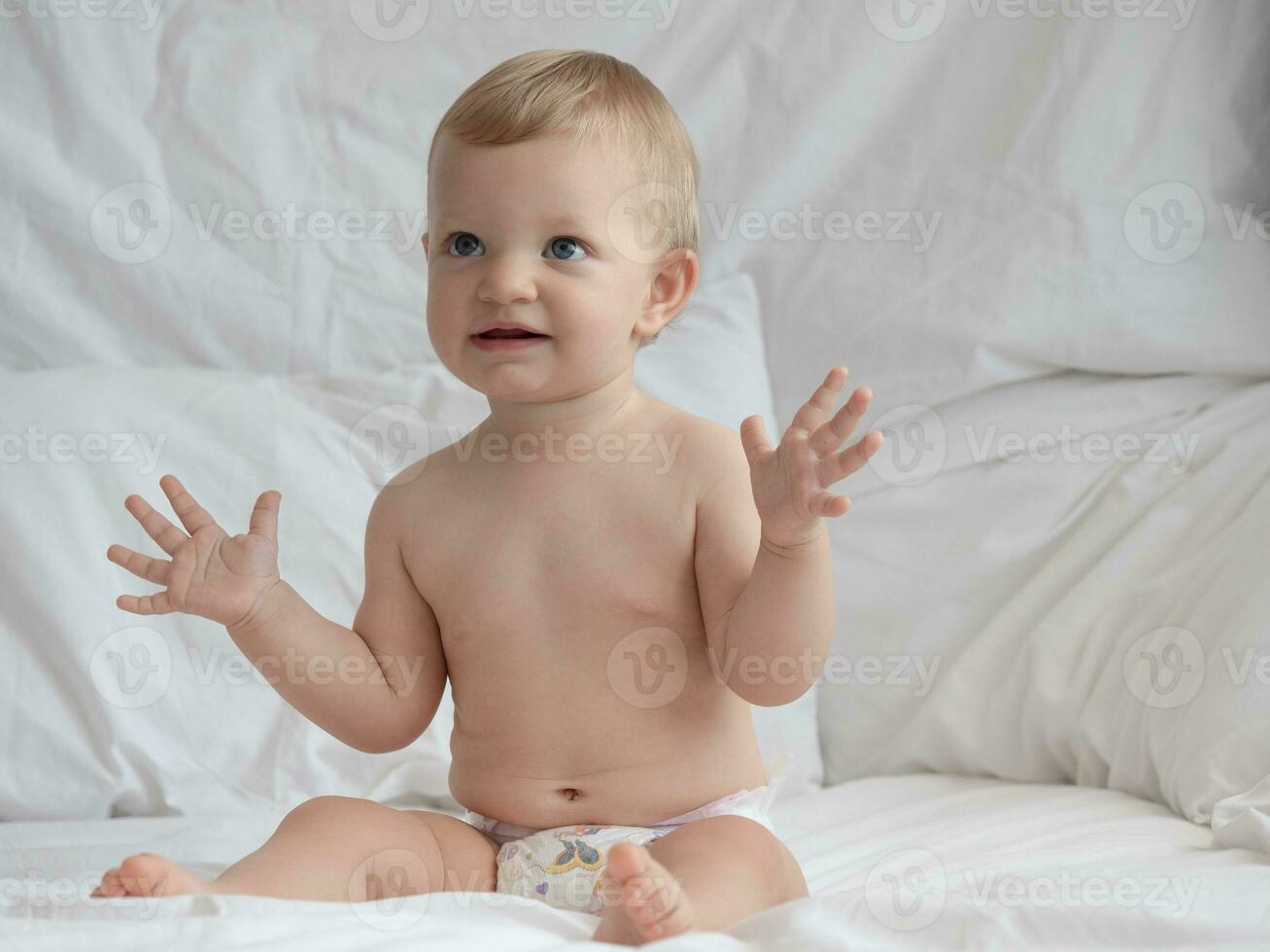 carino bambino seduta e sorridente su il letto foto