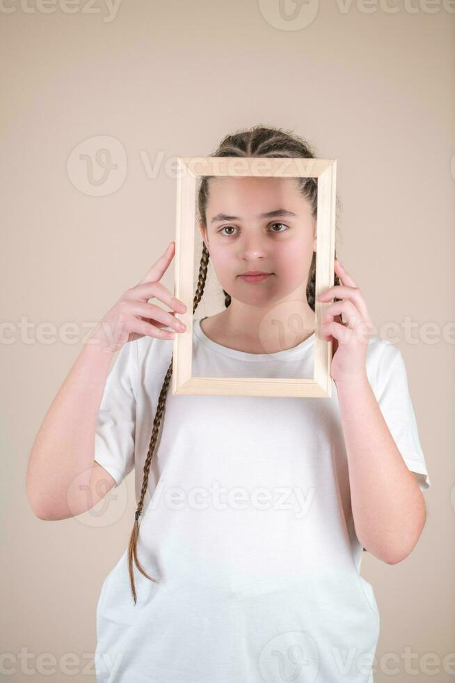 ritratto di un' carino poco ragazza Tenere un' immagine telaio. studio tiro foto