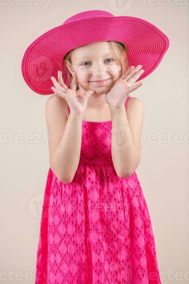 poco ragazza con rosa vestito e cappello foto