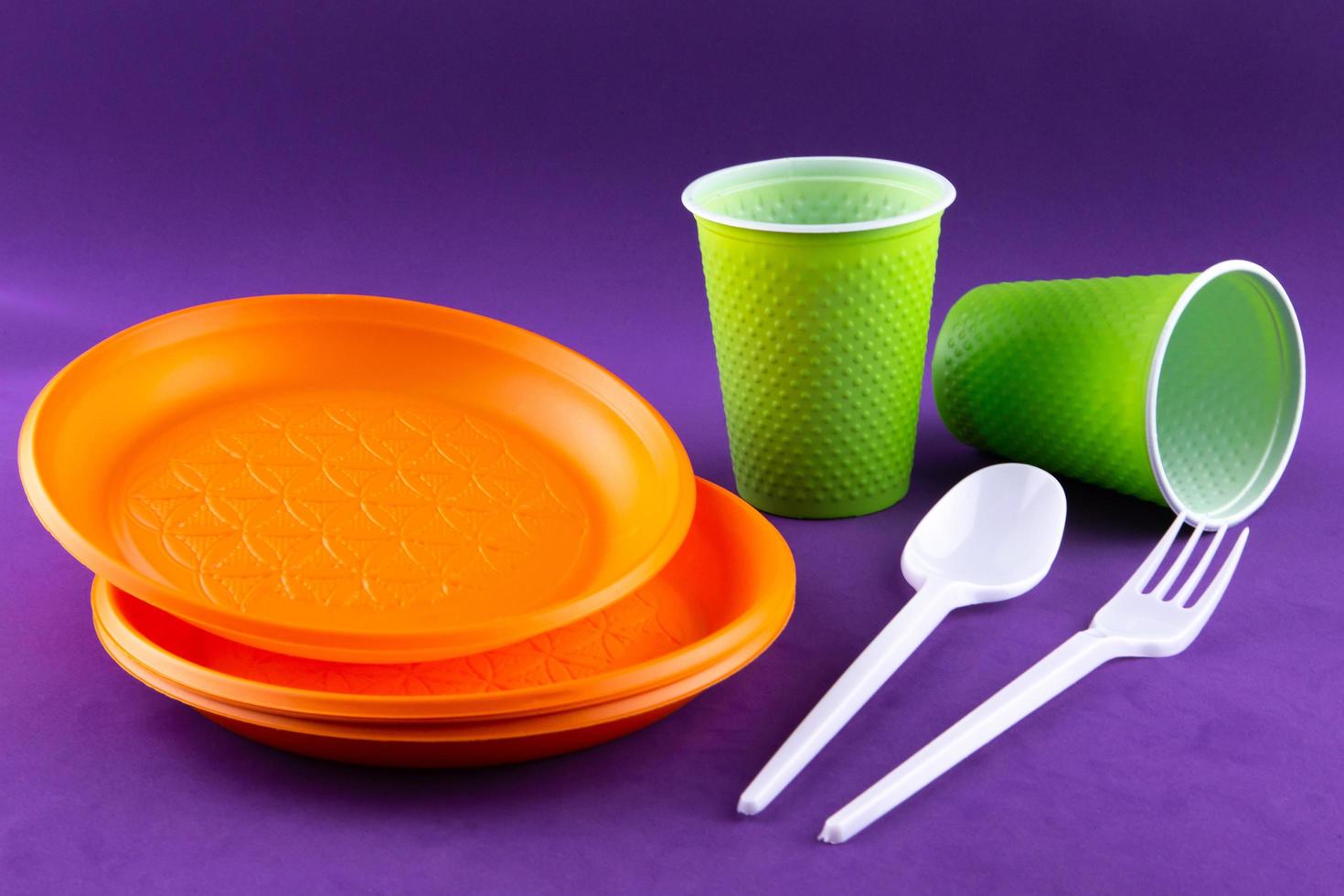 raccolta dei rifiuti di plastica arancione verde su sfondo viola foto