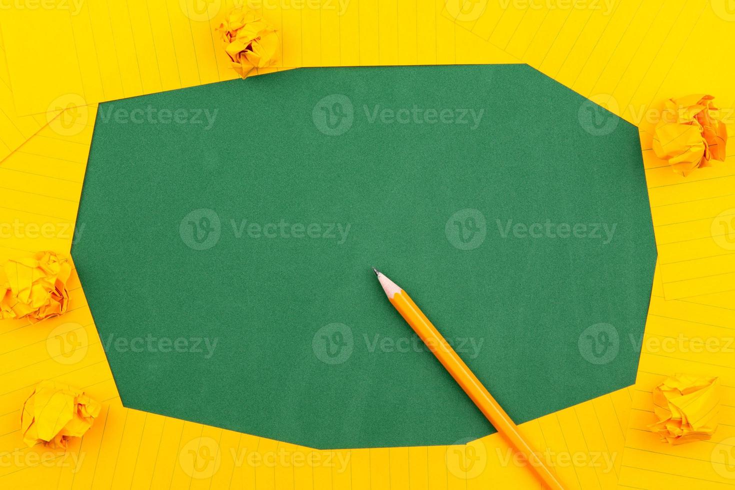 un foglio di carta arancione giace su un consiglio scolastico verde foto