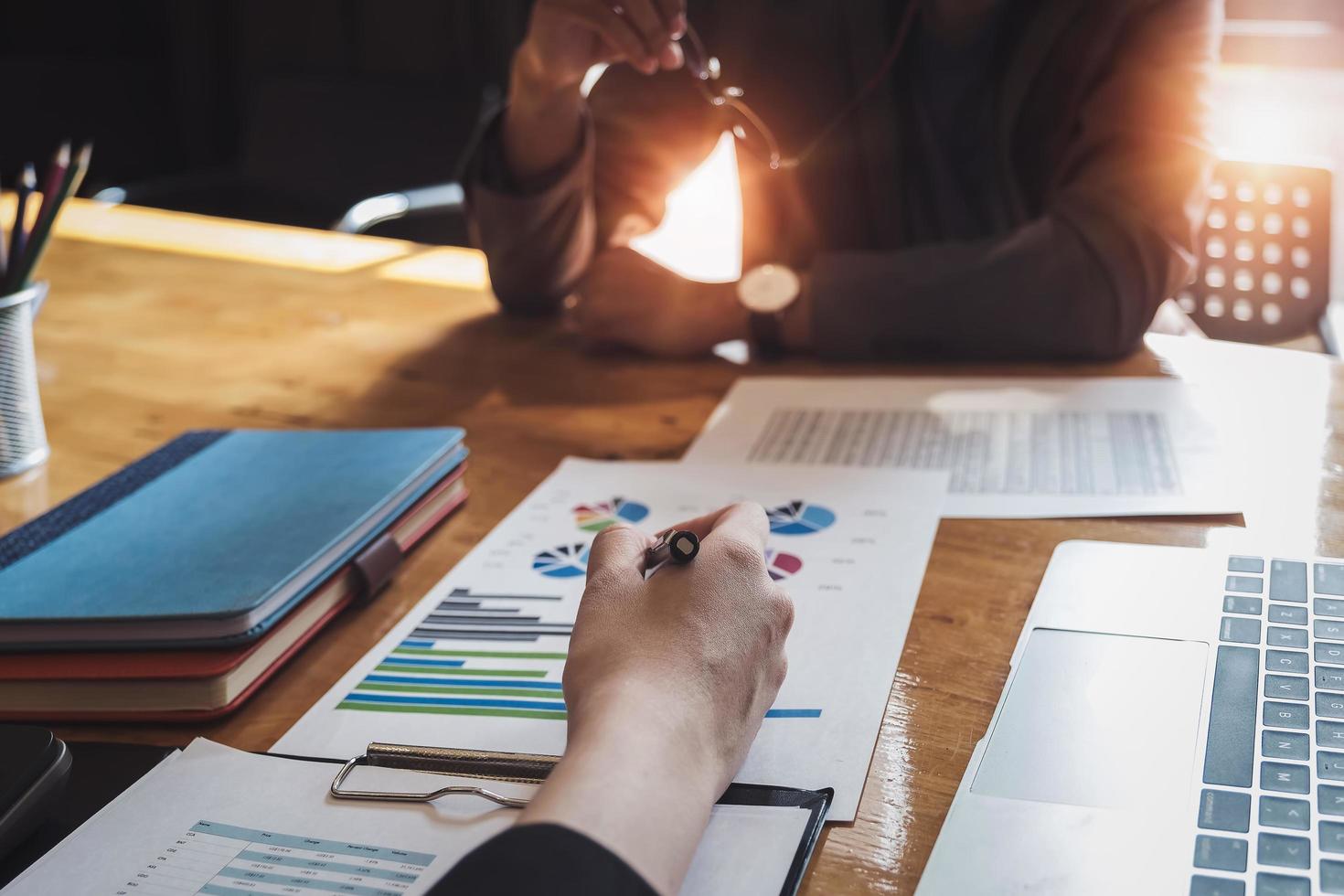 gli imprenditori stanno consultando gli economisti per migliorare la società è il piano di investimento con l'utilizzo di laptop e grafico di marketing azionario per le imprese spiegano foto