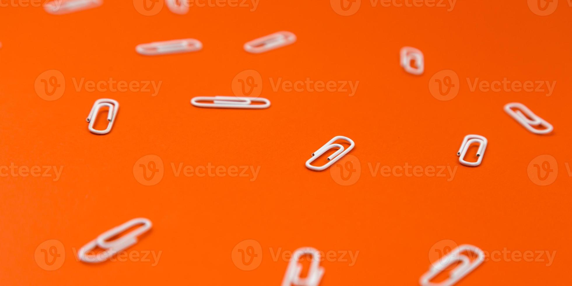 Close-up di graffette bianche su uno sfondo arancione foto