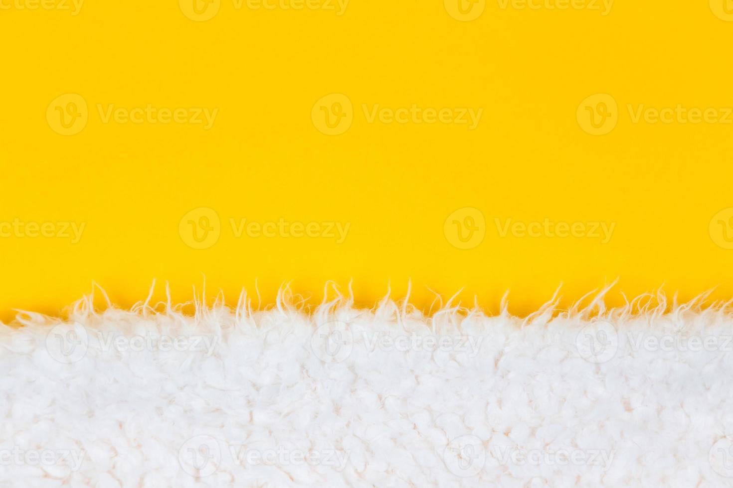 primo piano bianco soffice pelliccia di lana di pecora su sfondo giallo foto