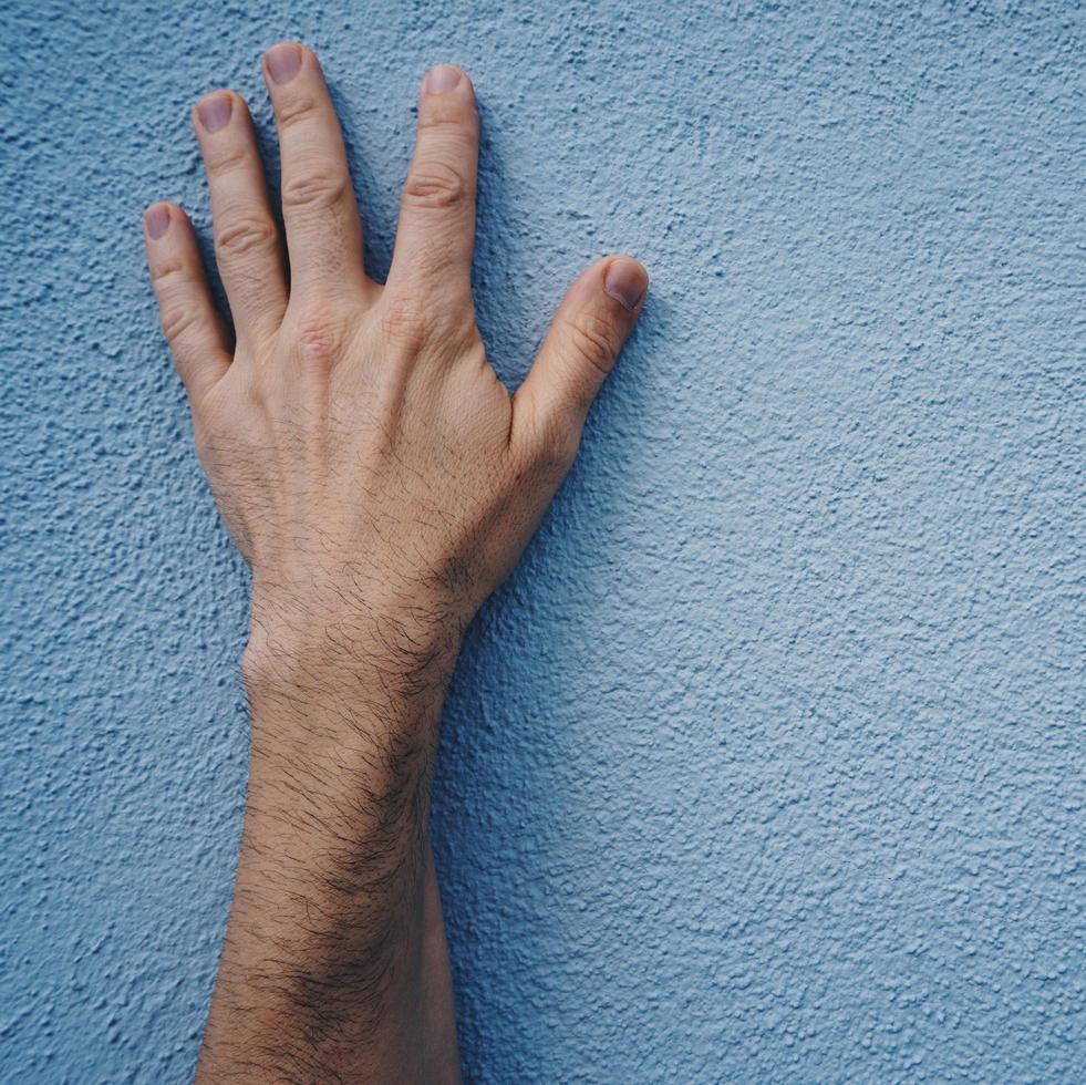 gesticolando con la mano sul muro foto