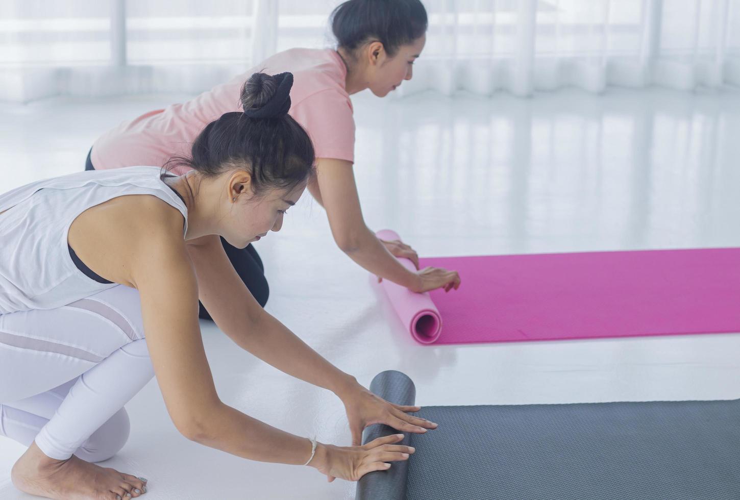 le donne asiatiche stanno preparando lo yoga in palestra foto