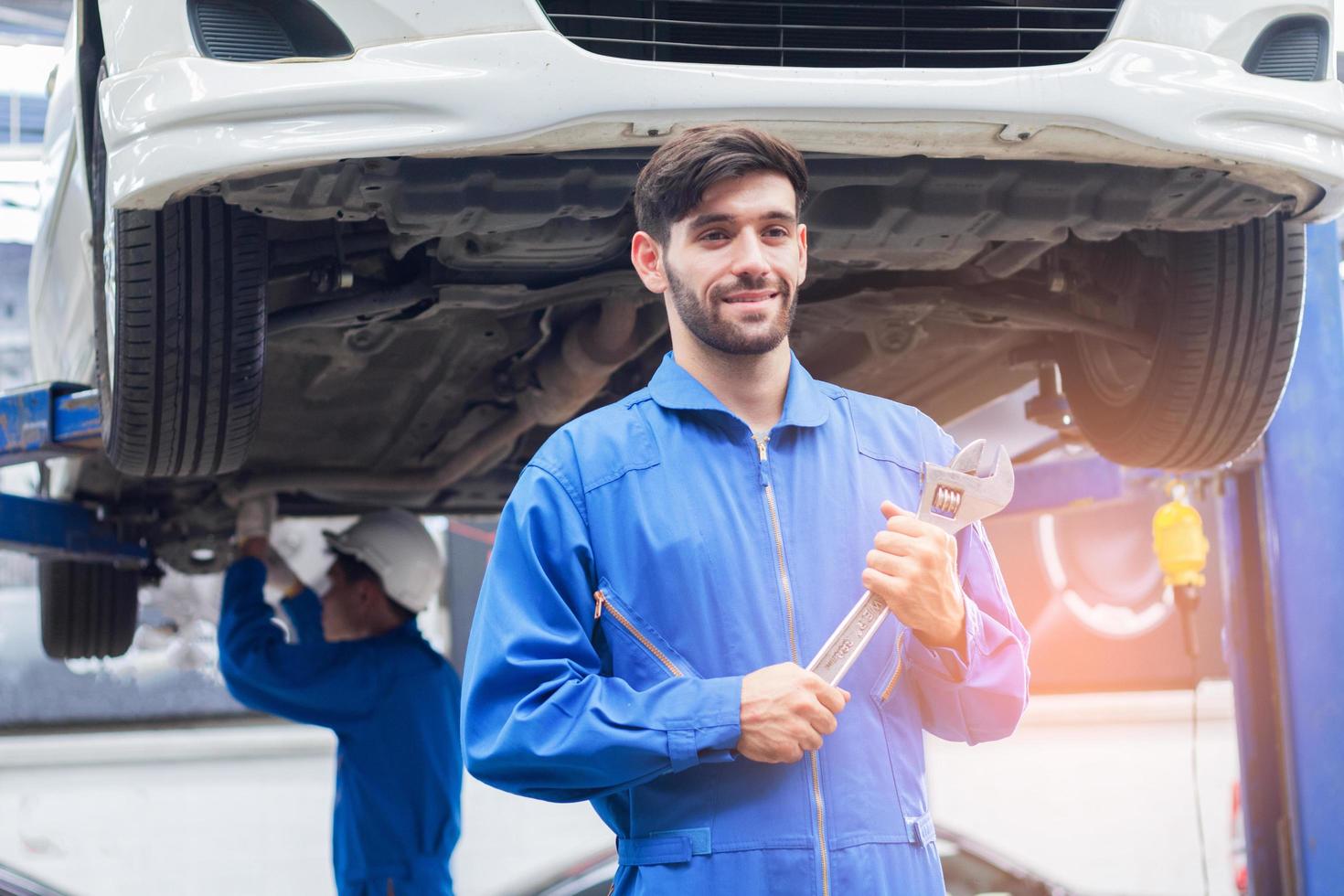 i tecnici del centro di assistenza auto sono in piedi con strumenti e pronti a fornire servizi professionali foto