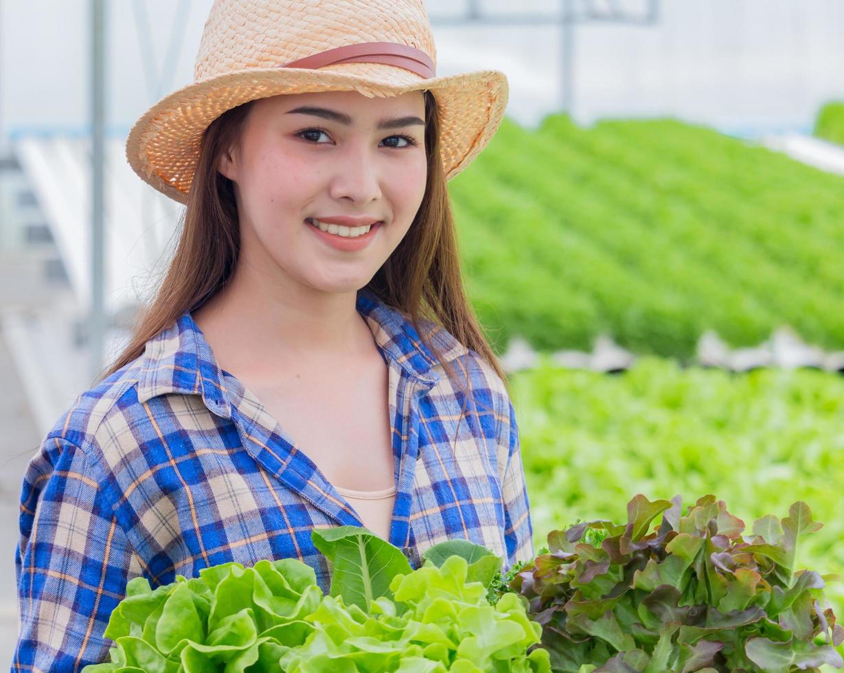 ritratto di una donna asiatica in possesso di un cesto di verdure fresche e ortaggi biologici foto