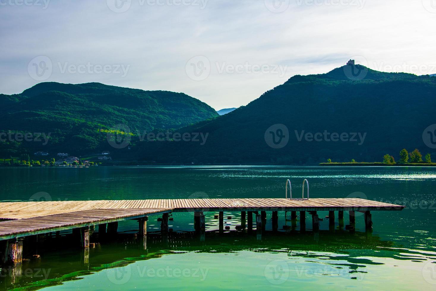 Piccolo molo in legno sul lago di Caldaro a Bolzano, Italia foto