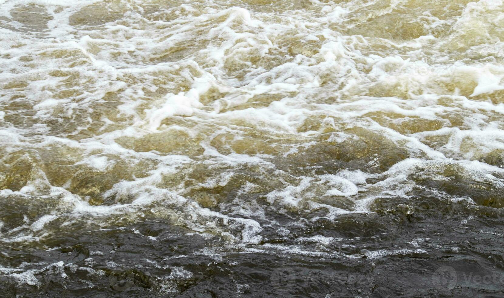 fiume rapide. vicino su astratto sfondo di caduta acqua. acqua flussi al di sopra di fiume rocce. un' bellissimo potente ruscello di un' tempestoso montagna fiume. il fiume si precipita con veloce acqua. foto