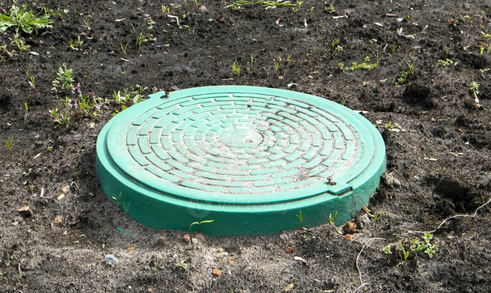 nuovo verde metallo tombino su il terra. riparazione opera. il chiuso tetto apribile fa non posa un' Pericolo per pedoni e veicoli. metropolitana tubatura riparazione. foto