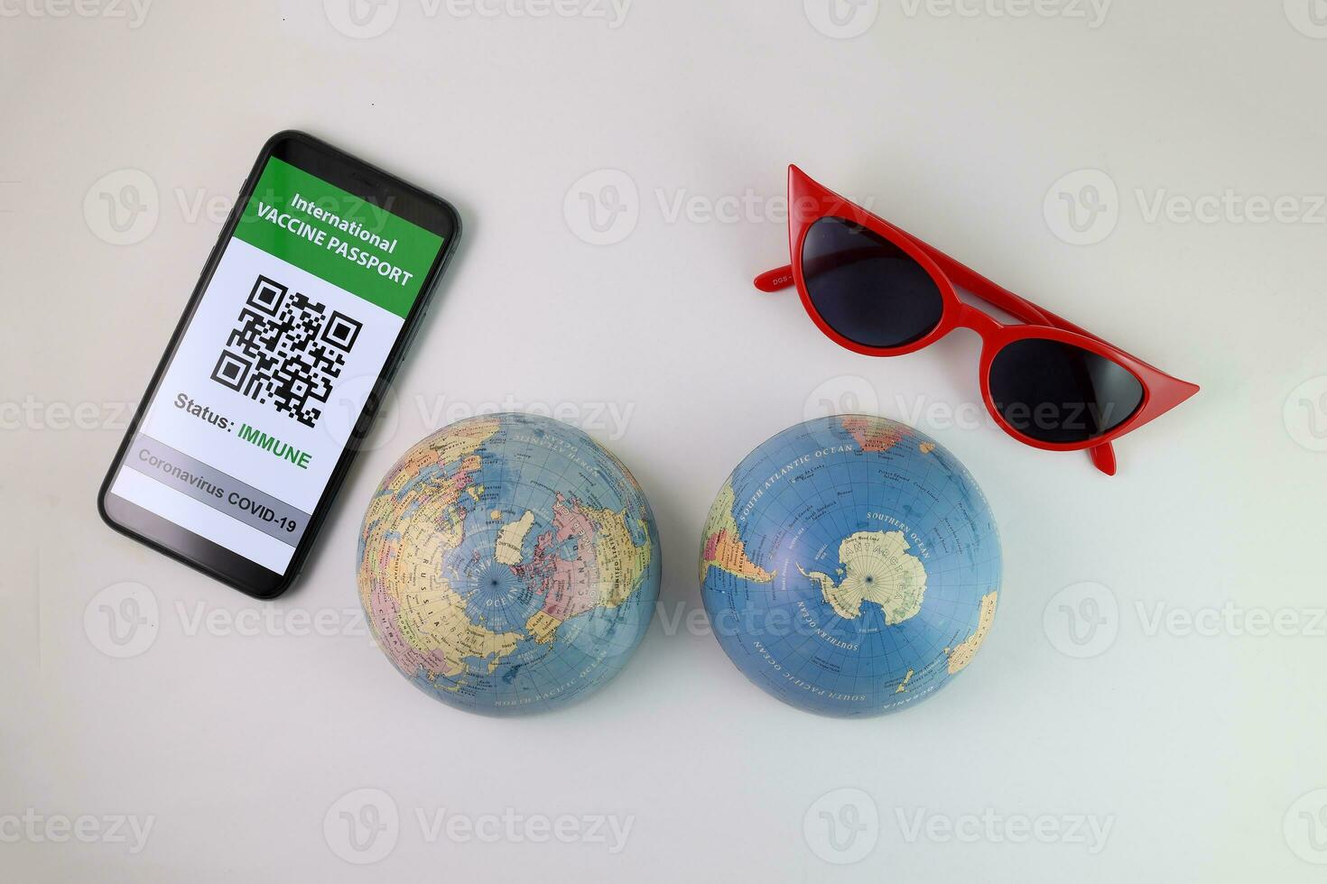 vaccino passaporto smartphone App rosso occhiali da sole mondo atlante globo carta geografica nord Sud polo su bianca sfondo mondo viaggio giro vacanza foto