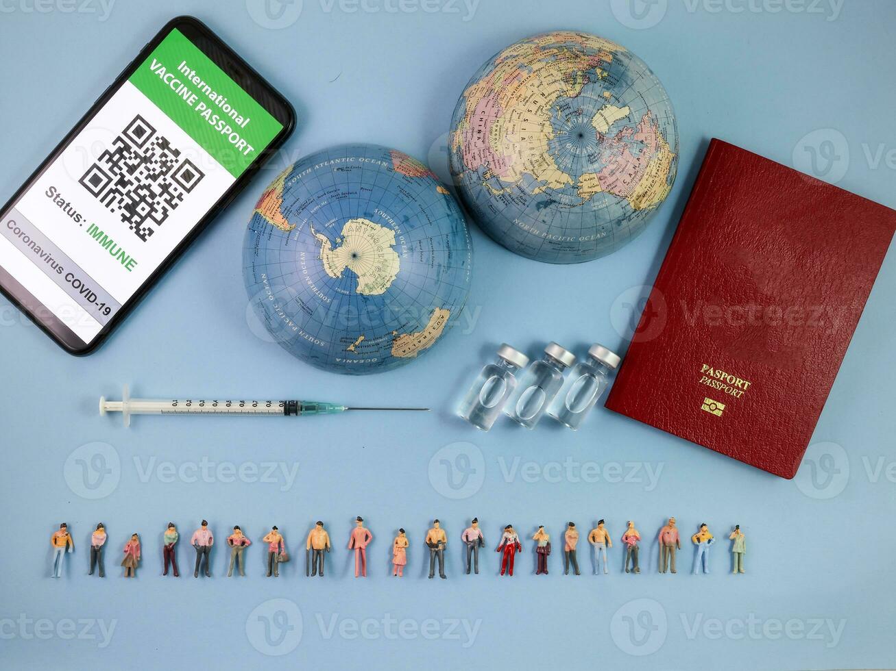 miniatura umano figura figurina maschio femmina Bambola riga vaccino passaporto digitale carta libro bottiglia medico iniezione siringa ago mondo carta geografica globo confine copia testo cartello spazio su blu carta sfondo foto