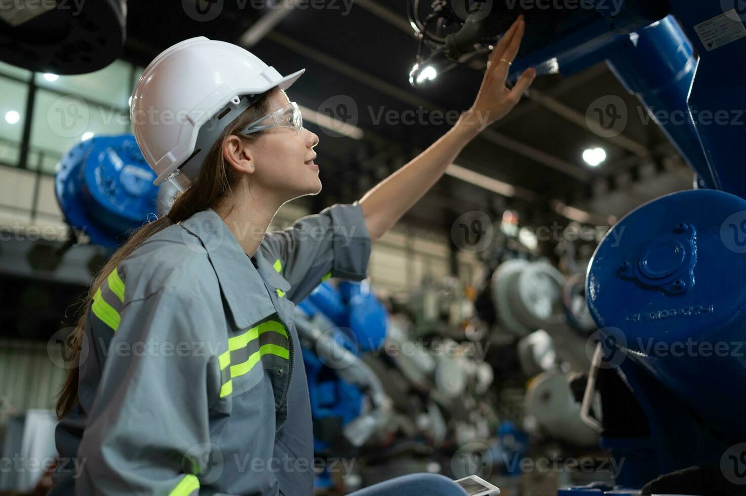 un' femmina ingegnere installa un' programma su un' robotica braccio nel un' robot magazzino. e test il operazione prima invio il macchina per il cliente. foto