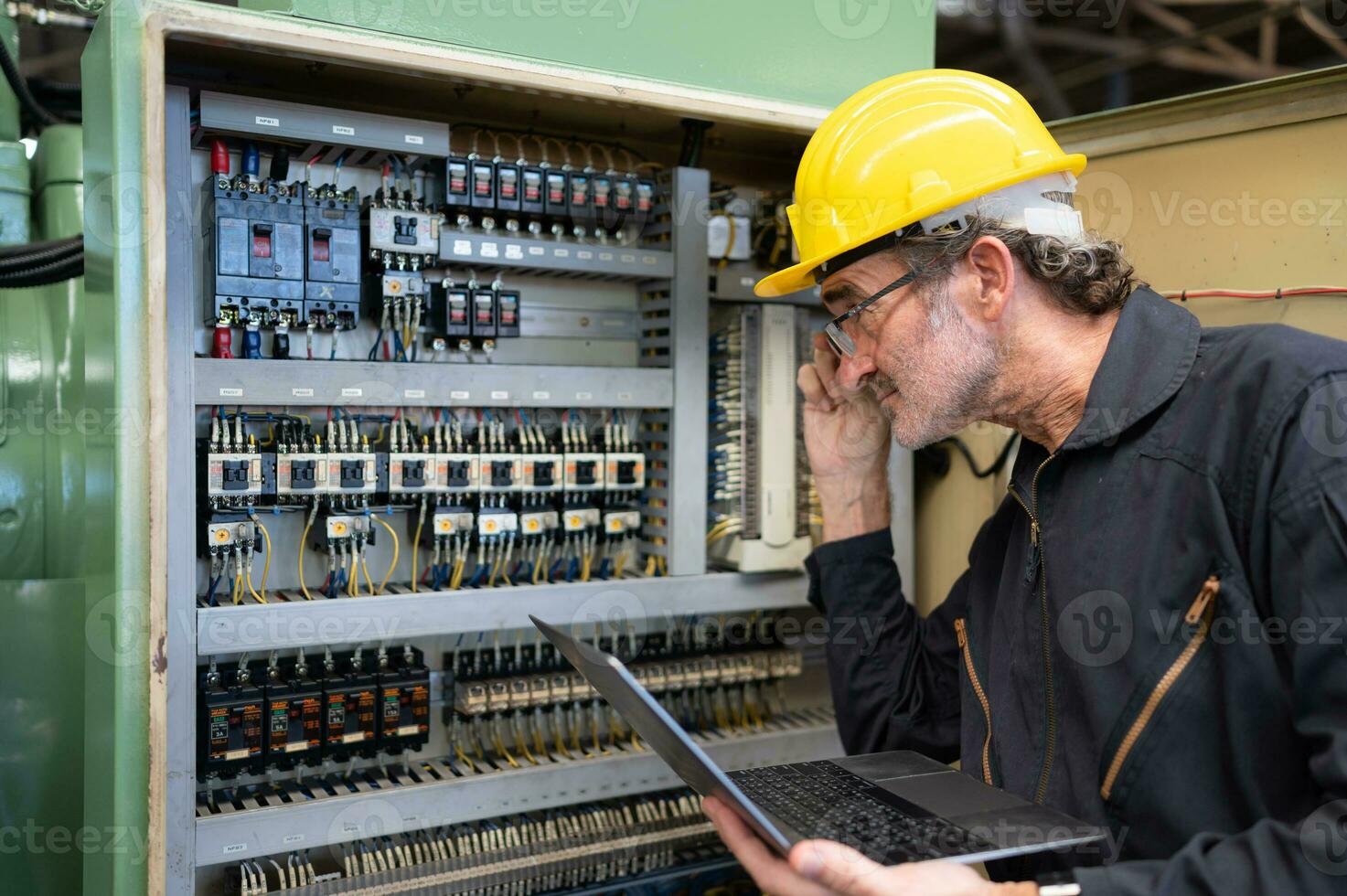 anziano ingegnere ispeziona il elettrico sistema e riparazione il meccanico sistema nel il macchina controllo mobiletto. nel ordine per il macchina per ritorno per normale operazione foto