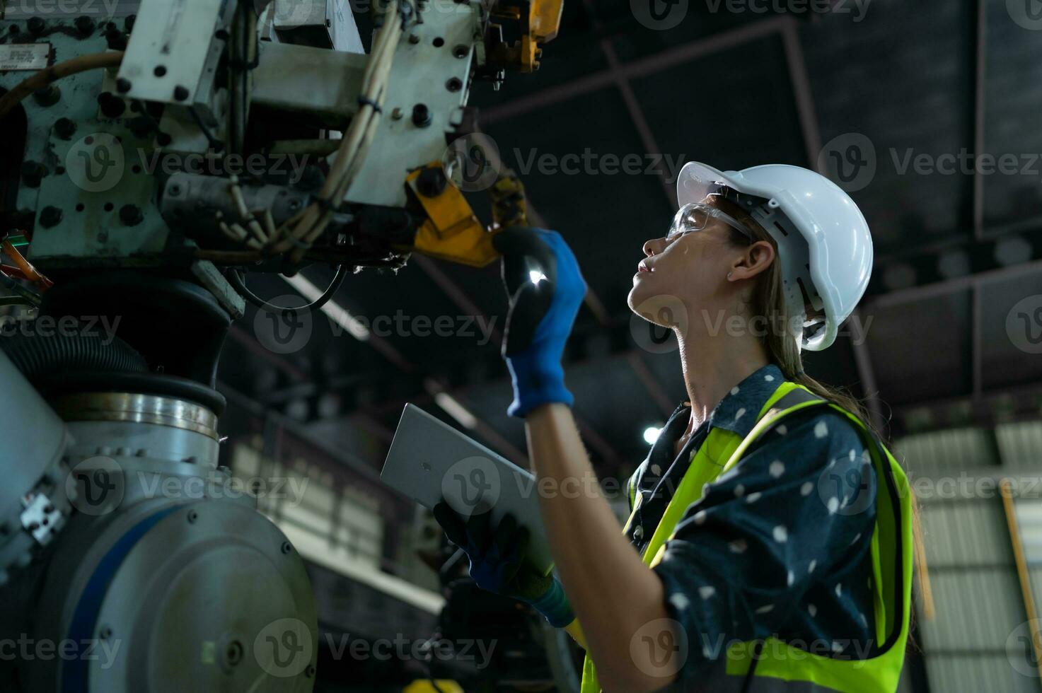 un' femmina ingegnere installa un' programma su un' robotica braccio nel un' robot magazzino. e test il operazione prima invio il macchina per il cliente. foto