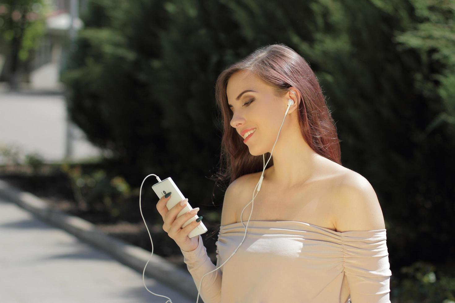 ragazza sorridente che ascolta la musica sul telefono cellulare foto