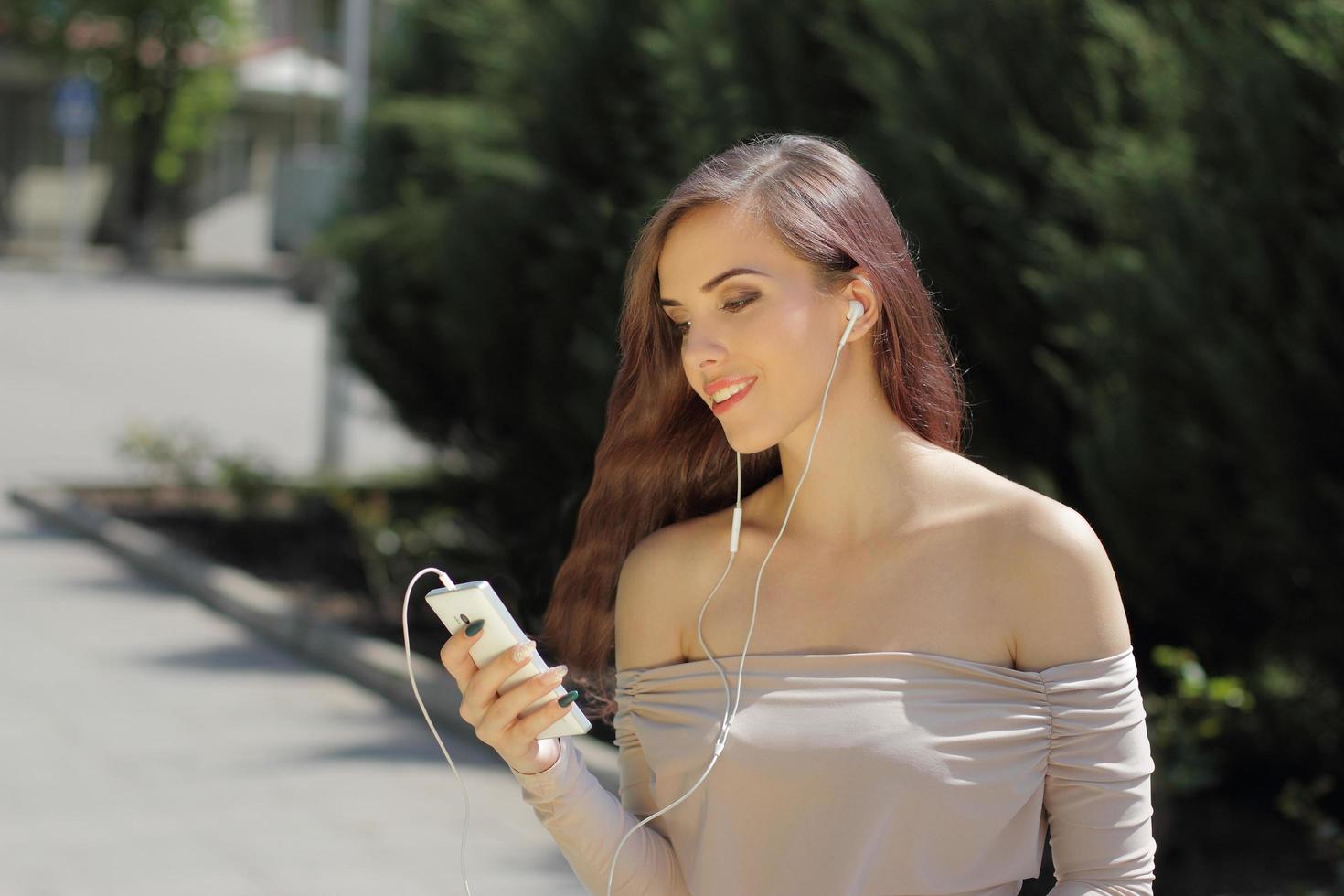 ragazza sorridente che ascolta la musica sul telefono cellulare foto