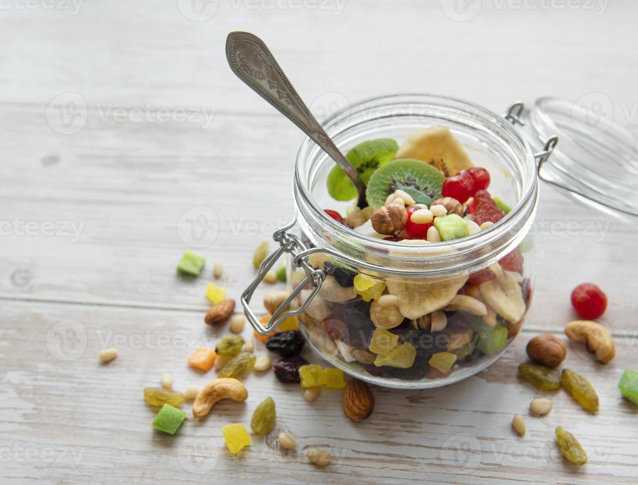 vaso di vetro con vari tipi di frutta secca e noci foto