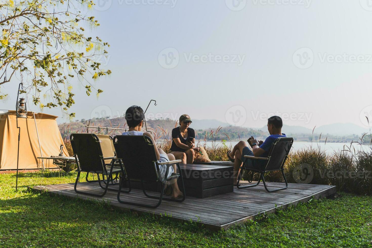 tre migliore amici seduta a campeggio natura all'aperto utilizzando mobile Telefono. foto