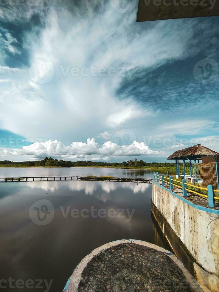Visualizza di il lago diga nel il pomeriggio con blu nuvole nel il sfondo foto