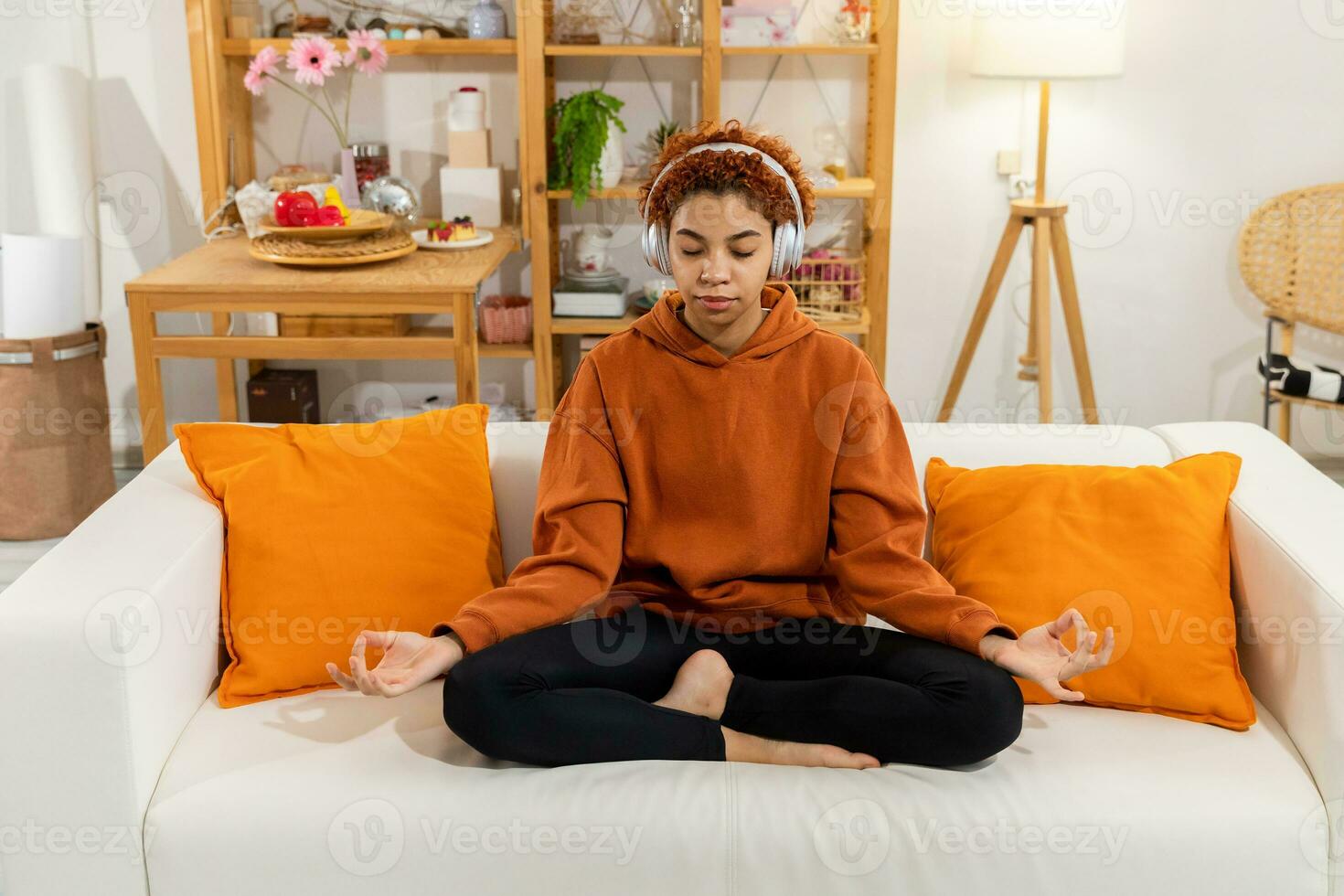 yoga consapevolezza meditazione. giovane salutare africano ragazza praticante yoga a casa. donna seduta nel loto posa su yoga stuoia Meditare sorridente rilassante interno. ragazza fare respirazione la pratica, yoga a casa foto