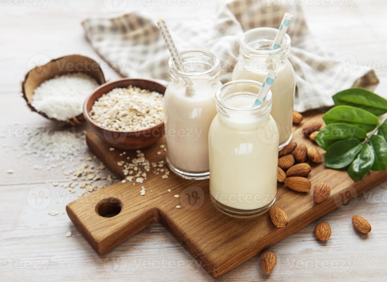 tipi alternativi di latte vegano in bottiglie di vetro foto