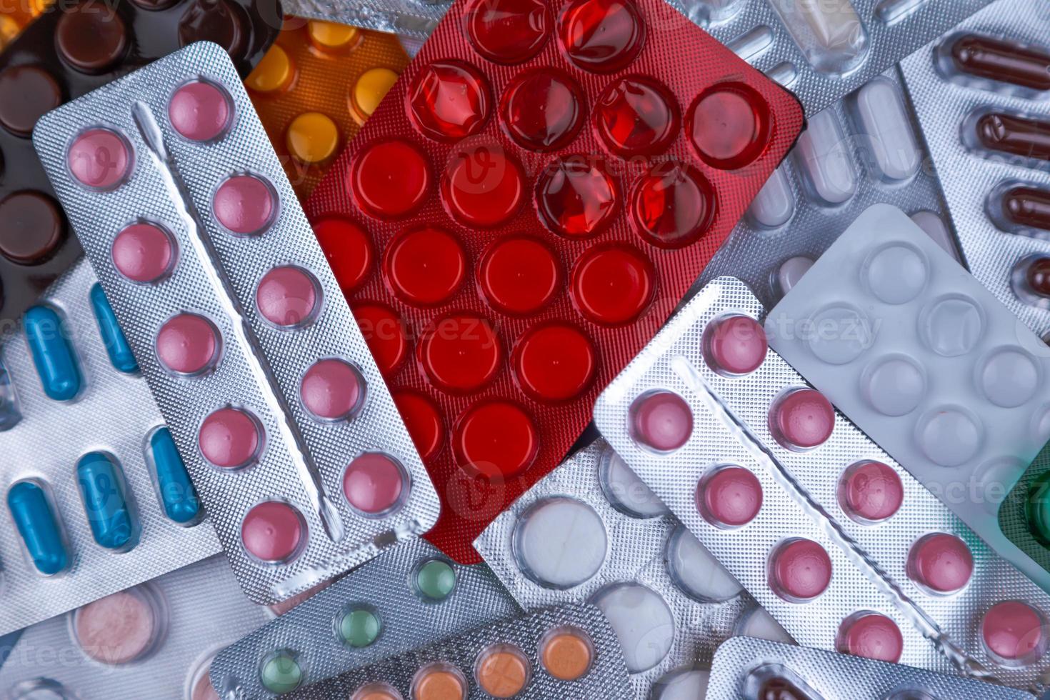 mucchio di pillole mediche in bianco blu e altri colori foto