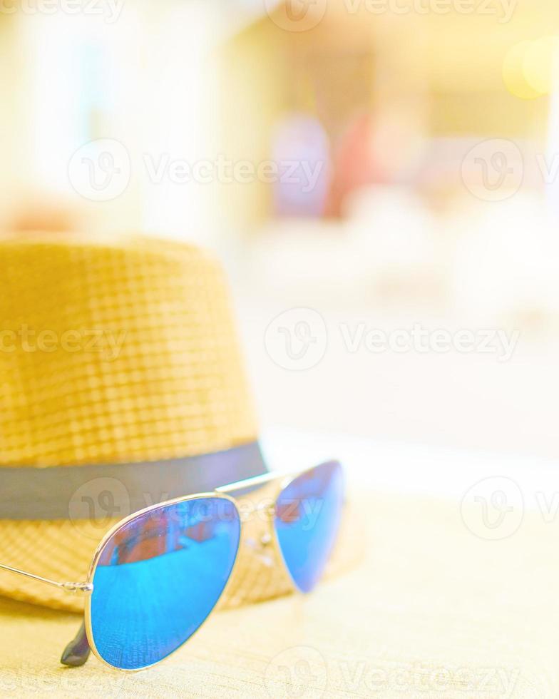 cappello e occhiali sul tavolo foto