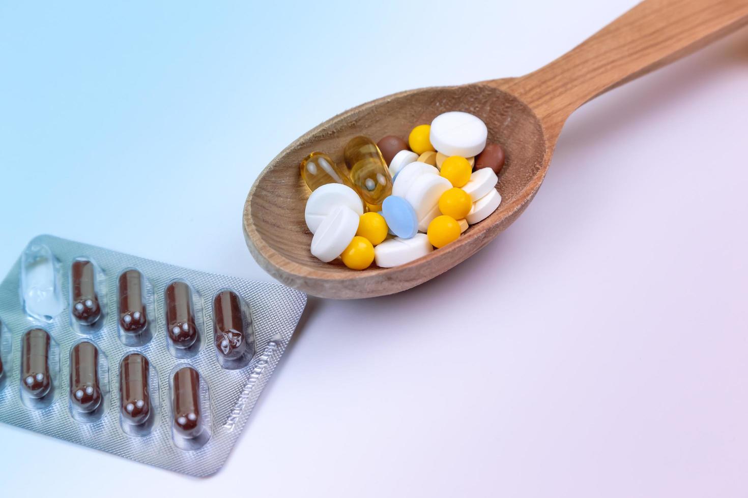 pillole medicinali e droga in un cucchiaio di legno con copia spazio foto