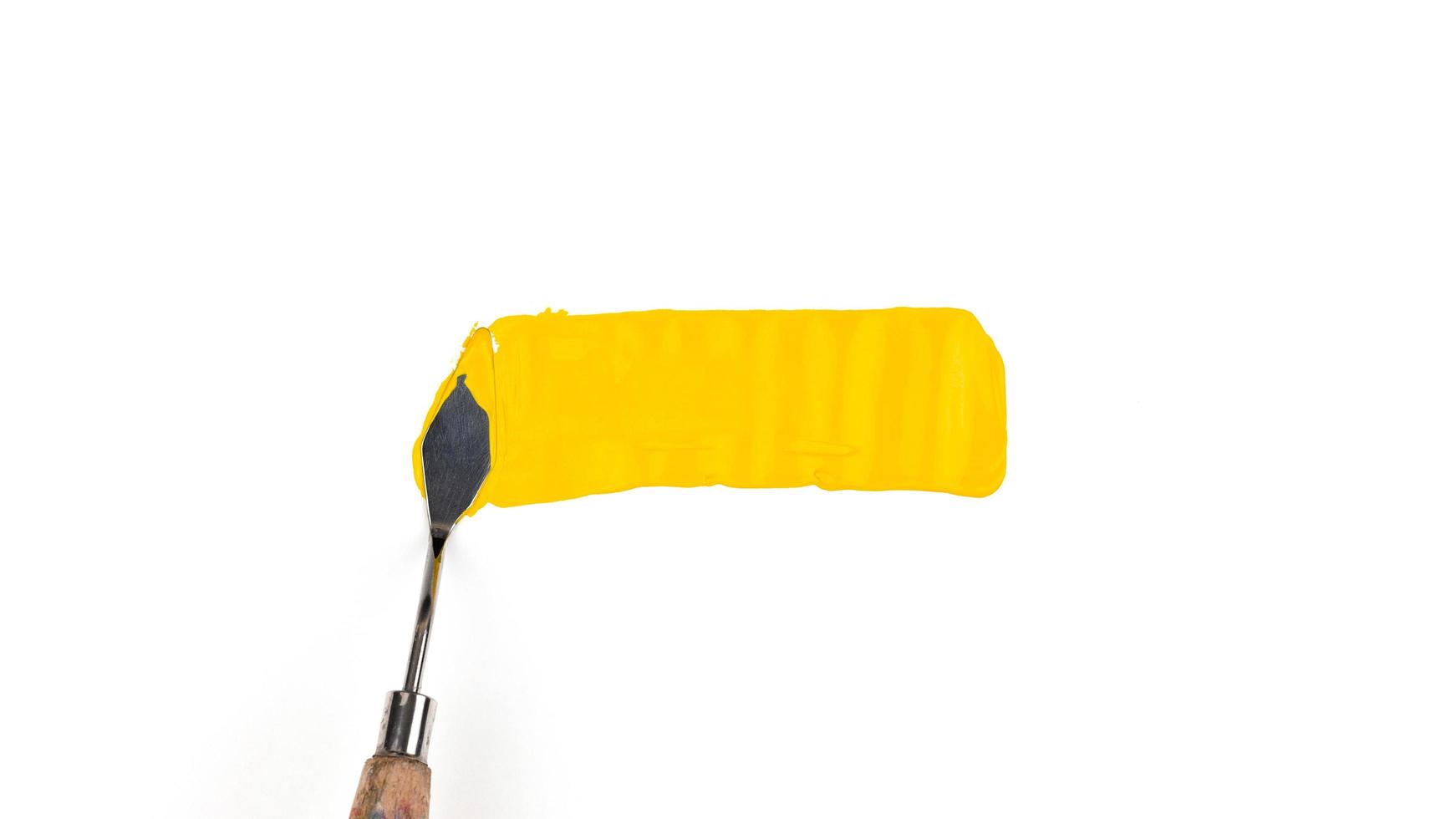 una spatola pittura isolato su uno sfondo bianco con il giallo foto