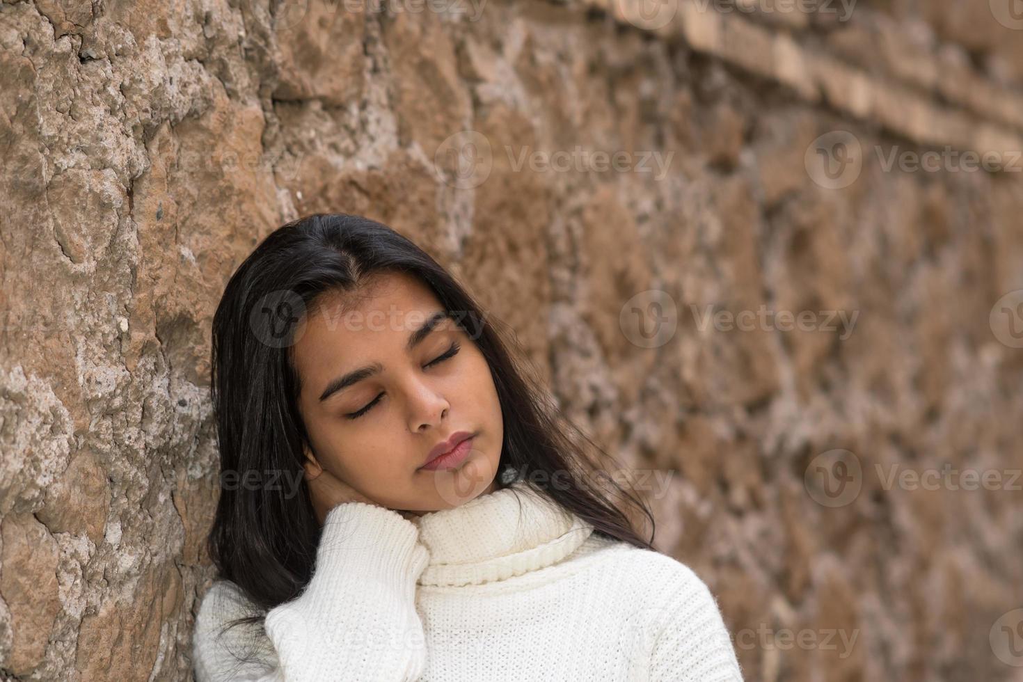 dolore al collo o rigidità giovane donna bruna chiudendo gli occhi massaggiandosi il collo sofferente foto