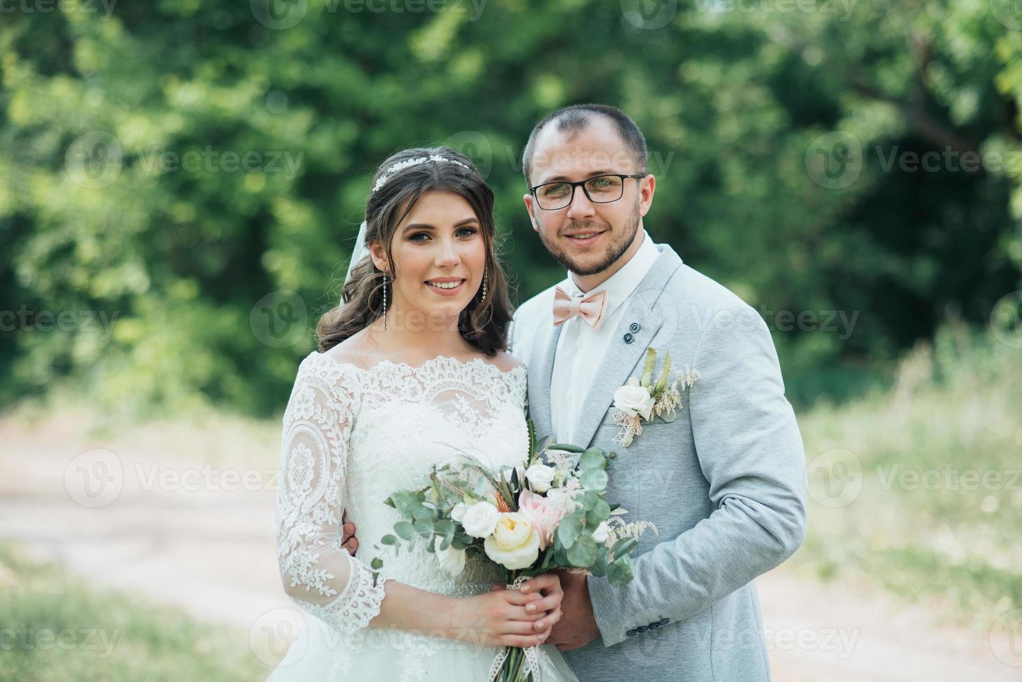 foto di matrimonio della sposa e dello sposo in un colore rosa grigio sulla natura nella foresta e nelle rocce