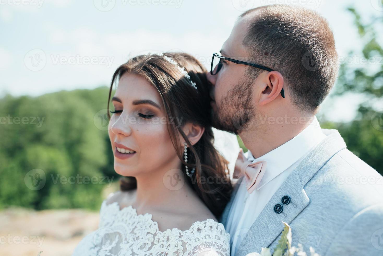 fotografia di matrimonio bacio sposa e sposo in luoghi diversi foto