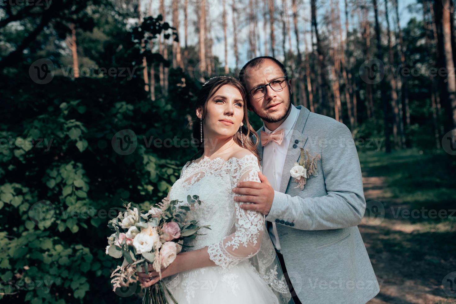 foto di matrimonio della sposa e dello sposo in un colore rosa grigio sulla natura nella foresta e nelle rocce